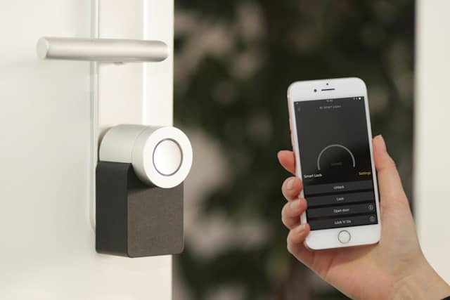 A homeowner with a security app on a smartphone